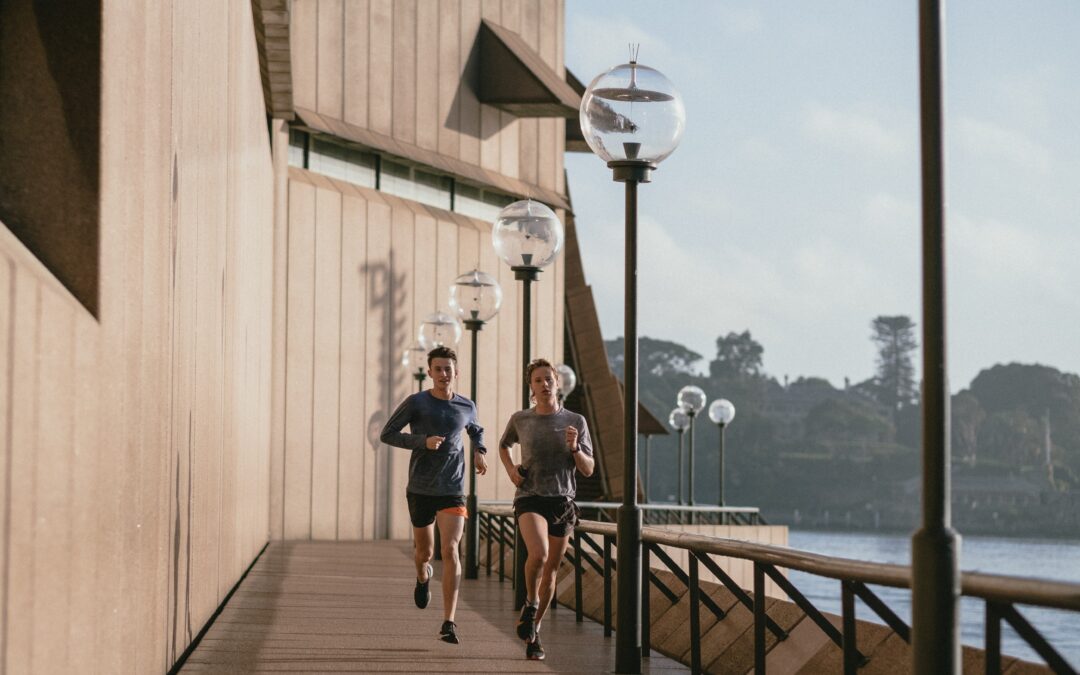 A couple runs along a pier.